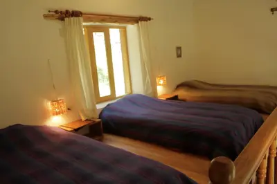 a bedroom with two beds and a window at Andean Spirit Lodge in Mollepata
