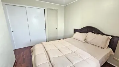 a bedroom with a large bed with white walls at Apartamento de 3 dormitorios frente a plaza San Miguel con Piscina in Lima