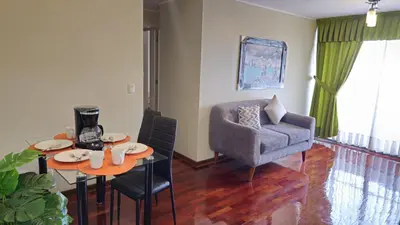 a living room with a chair and a table and a couch at Apartamento de 3 dormitorios frente a plaza San Miguel con Piscina in Lima