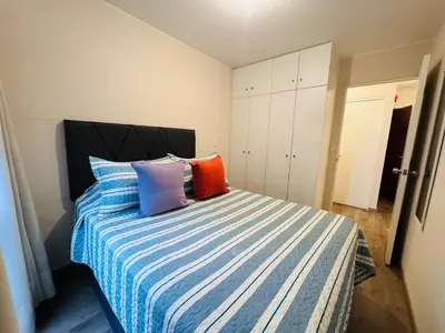 a bedroom with a bed with colorful pillows on it at MONTERRICO POLO APARTS #21 - Dpto 2 Dorm Frente Embajada de USA in Lima