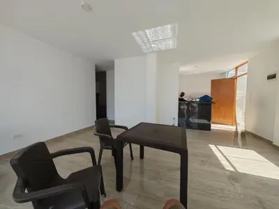 a room with a table and chairs and a kitchen at Habitacion con Cochera in Atico