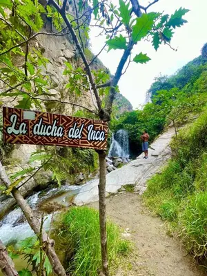 a sign on a path next to a waterfall at Restobar & Hotel Campestre Aisha in Cocachacra