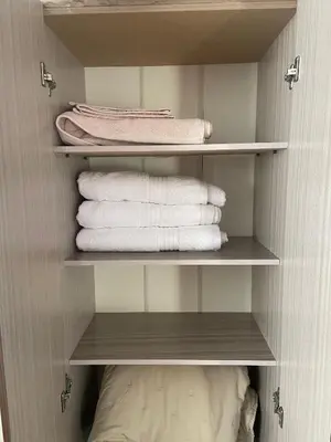 a closet with white towels and a pile of towels at Galicia Lodgement in Lima