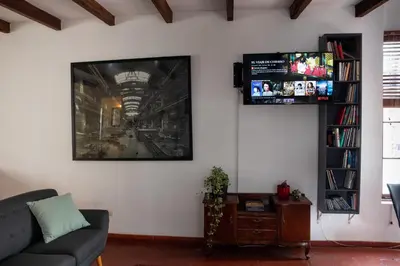 a living room with a couch and a tv on a wall at The film House in Lima