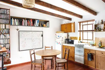 a kitchen with a table and chairs and a refrigerator at The film House in Lima