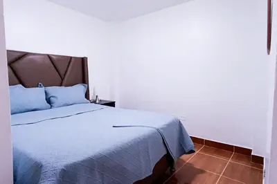 a bedroom with a large bed with blue pillows at Cozy Apartment for Tourist in Lima