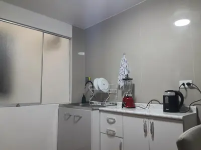 a kitchen with white cabinets and a blender at Cozy Apartment for Tourist in Lima