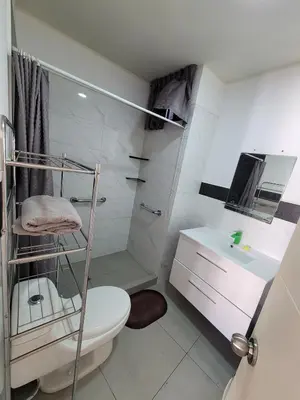 a white bathroom with a toilet and a sink at 1cuarto 2 camas baño privado in Lima