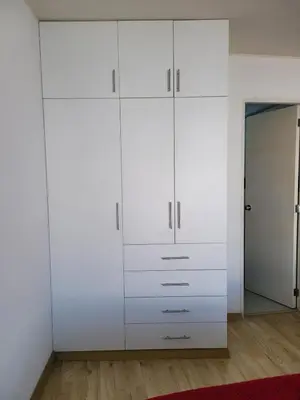a white closet with white cabinets and a red rug at 1cuarto 2 camas baño privado in Lima