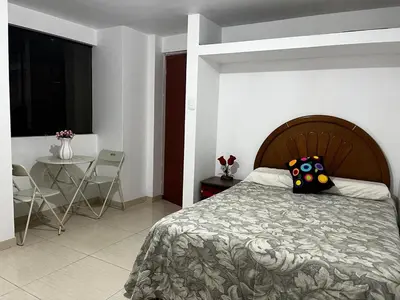 a bedroom with a bed and a table with chairs at Departamento Centro Histórico in Ayacucho