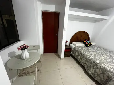 a bedroom with a bed and a table with a vase on it at Departamento Centro Histórico in Ayacucho