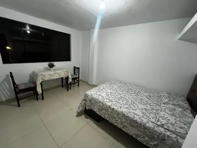 a bedroom with a bed and a table and a television at Departamento Centro Histórico in Ayacucho
