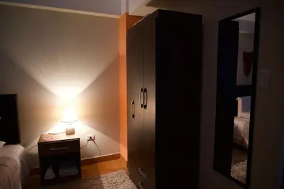 a bedroom with a bed and a dresser with a lamp at Casa Secretos in Cusco