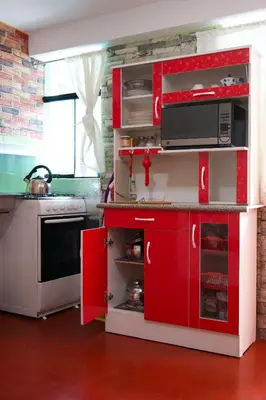 a kitchen with red cabinets and a microwave at Casa Secretos in Cusco