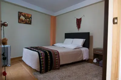 a bedroom with a bed with white sheets and pillows at Casa Secretos in Cusco