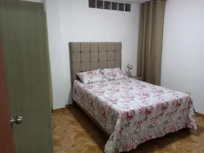 a bedroom with a bed with a red and white blanket at Departamento en Centro de Lima - Santa Beatriz in Lima