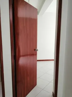 a wooden door in a room with a white tile floor at Apartamento en Ayacucho in Ayacucho