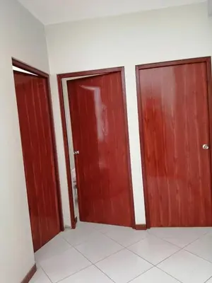 three wooden doors in a room with a tile floor at Apartamento en Ayacucho in Ayacucho