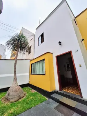 a house with a palm tree in front of it at Casa Villa Descanso in Lima