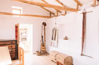 a room with white walls and a guitar on the wall at Casa Takiy in Maras