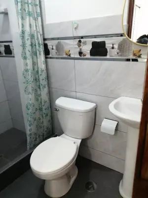 a bathroom with a white toilet and a sink at Alojamiento Miller in Ayacucho