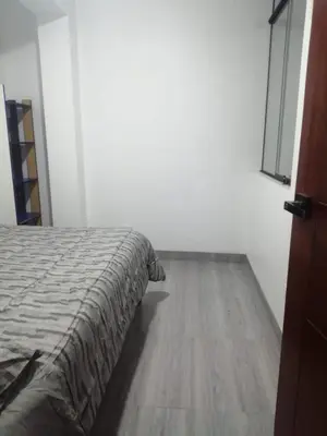 a bedroom with a bed and a wooden floor at Alojamiento Miller in Ayacucho