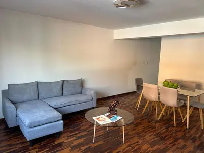 a living room with a blue couch and a table at Apartment - US Embassy in Lima