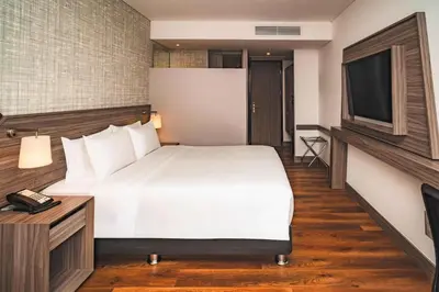 a hotel room with a bed and a television at Hampton By Hilton Cusco in Cusco