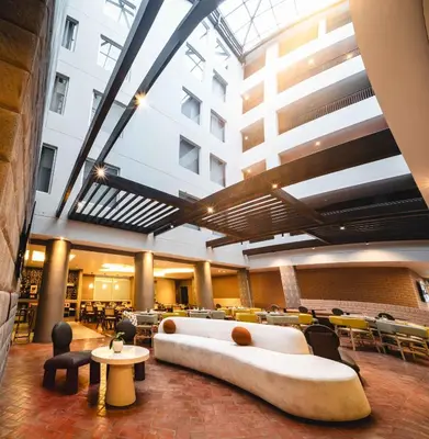 a lobby with a large couch in the middle of a building at Hampton By Hilton Cusco in Cusco