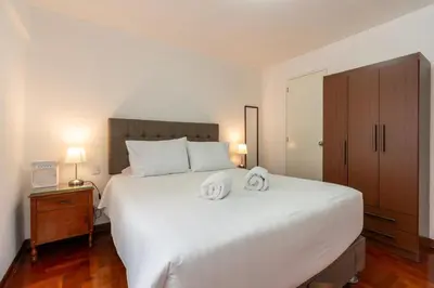 a bedroom with a large white bed with two towels on it at Basílica 3BR by Geko in Lima