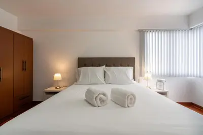 a bedroom with a large white bed with two pillows at Basílica 3BR by Geko in Lima