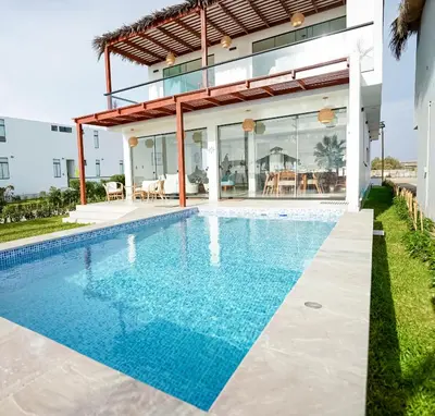 a swimming pool in front of a house at Casa de playa en Chincha Baja in Chincha Baja