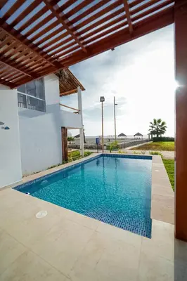 a swimming pool in front of a house at Casa de playa en Chincha Baja in Chincha Baja