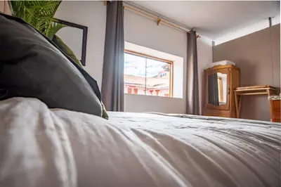 a bedroom with a bed with a pillow and a window at Alojamiento en Centro Histórico Cusco in Cusco