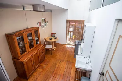 a kitchen with a wooden floor and a refrigerator at Alojamiento en Centro Histórico Cusco in Cusco