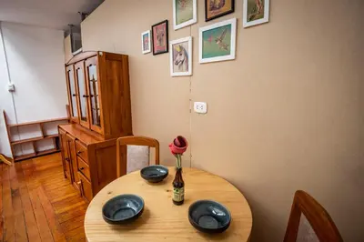 a dining room table with a vase with a rose on it at Alojamiento en Centro Histórico Cusco in Cusco