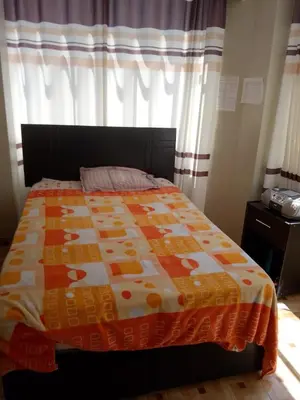 a bed with a quilt on it in a bedroom at Macchi in Ayacucho