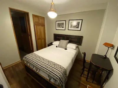 a bedroom with a bed and a lamp and a chair at Artinka Boutique Hotel in Cusco