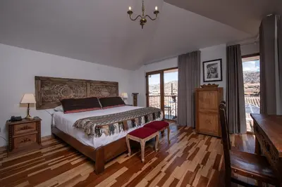 a bedroom with a large bed and a balcony at Artinka Boutique Hotel in Cusco