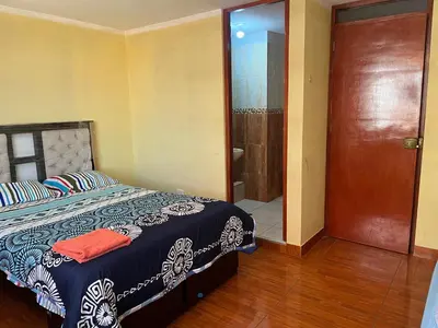 a bedroom with a bed and a sliding glass door at Habitación 2 camas y baño privado in Ayacucho
