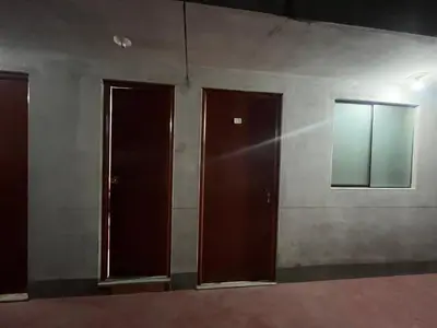 three brown doors in a room with a wall at Habitación 2 camas in Ayacucho