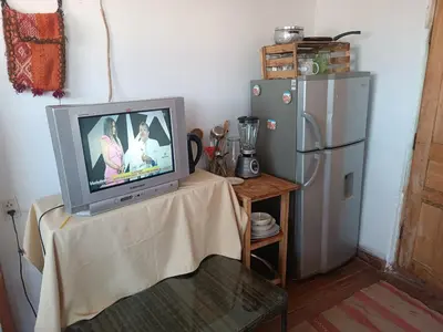 a tv sitting on a table next to a refrigerator at Sanblas House in Cusco