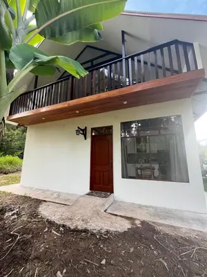 a small house with a balcony on top of it at Albano Casa en bosque de conservación privado in Oxapampa