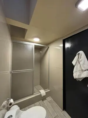 a bathroom with a toilet and a glass shower at Serendipia Studio Loft in San Isidro 205 in Lima