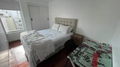 a small bedroom with a bed and a window at Brand new modern apartment in Lima