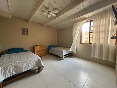 a bedroom with two beds and a window at Hospedaje El Cairo in Ica
