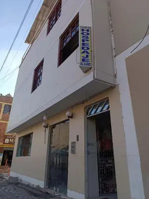 a white building with a sign on the side of it at Hospedaje El Cairo in Ica