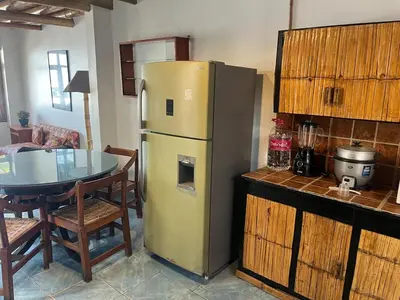 a kitchen with a table and a yellow refrigerator at Playa El Silencio House Facing the Sea in Bombiso