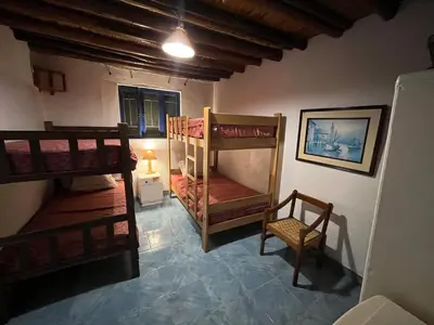 a room with two bunk beds and a chair at Playa El Silencio House Facing the Sea in Bombiso