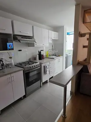 a kitchen with white cabinets and a stove top oven at Departamento 3 Dormitorios en Ñaña - Con Cochera in Chosica